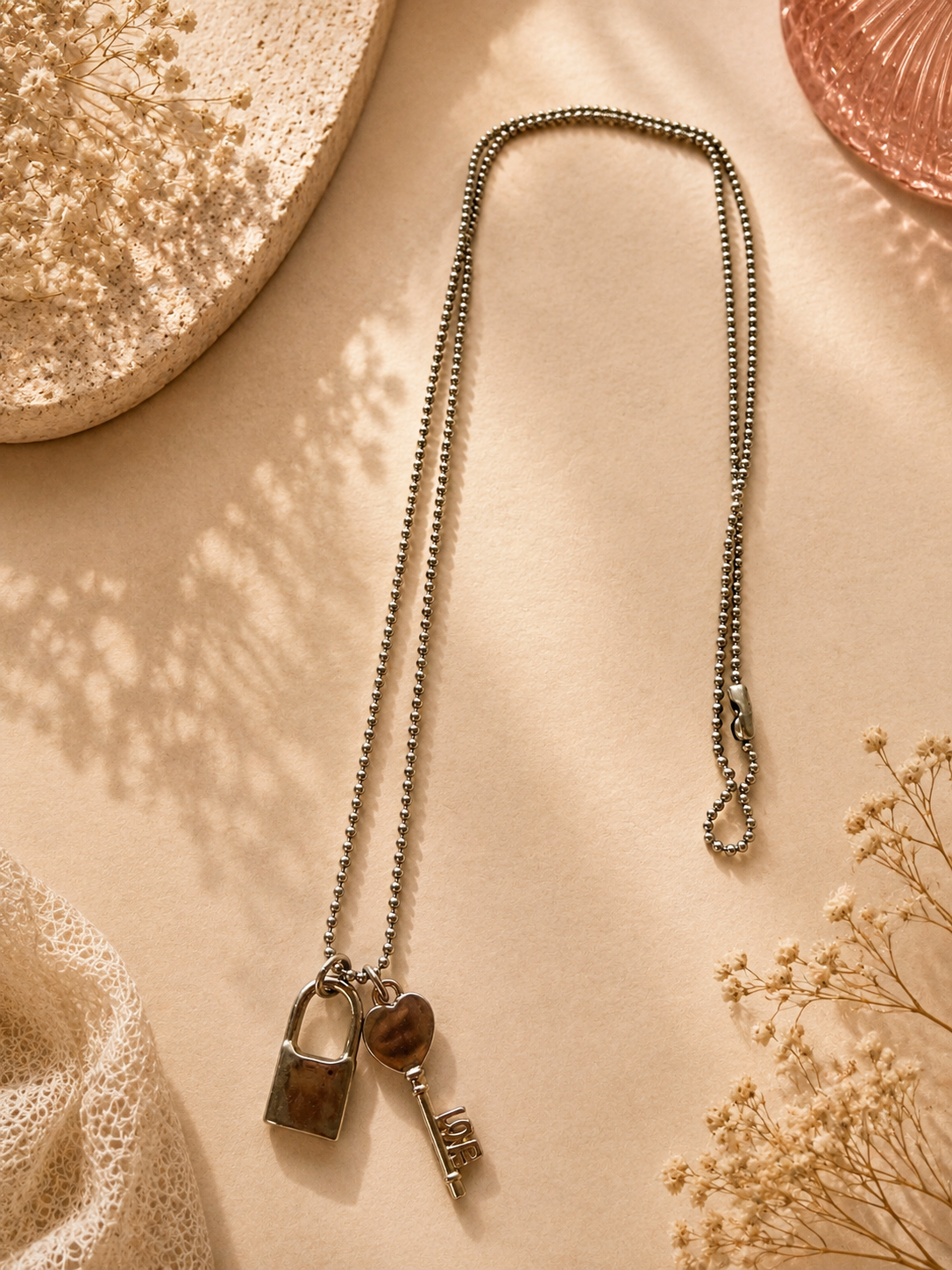 Lange zilverkleurige ketting met rosé gouden sleutel- en slotbedels | By Jule Sieraden